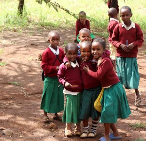 Joyful children in school uniforms playing outdoors, showing camaraderie and happiness.