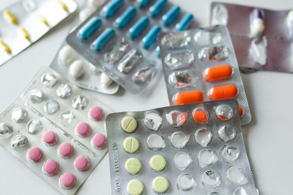 pexels photo 3873149 3873149 Assorted colorful blister packs of pills and capsules on a white surface.