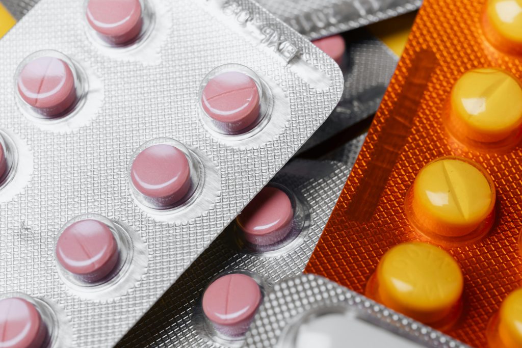 pexels photo 4210607 4210607 From above closeup mix of various multicolored round pills of different sizes in plastic blister packs under bright light
