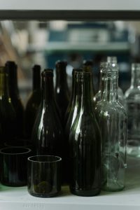 A collection of empty glass bottles in various colors, ready for recycling.