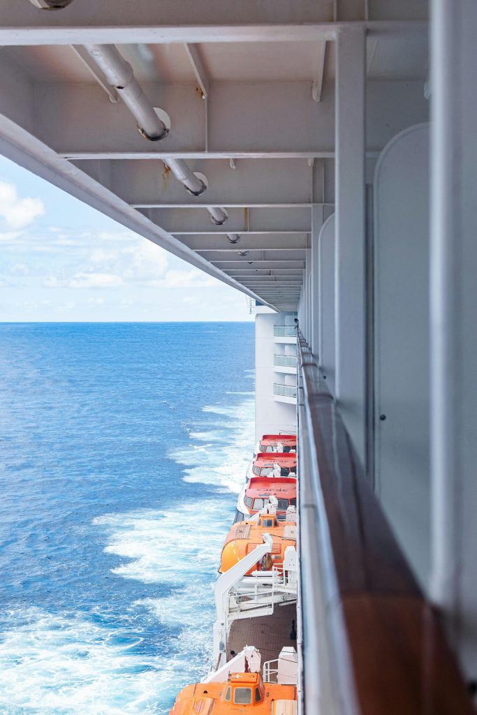 pexels photo 29863939 29863939 Side view of a cruise ship at sea with open ocean and lifeboats visible.
