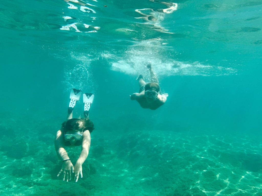 pexels photo 33968347 33968347 Two adults snorkeling underwater in a clear blue sea with fins and masks.