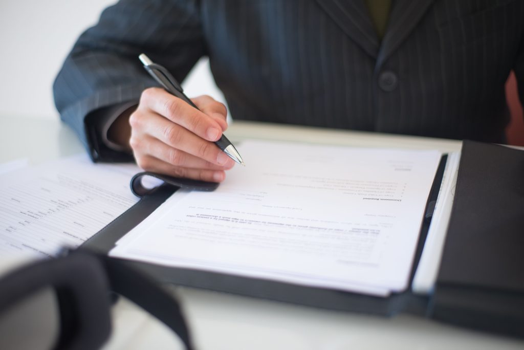 pexels photo 8815849 8815849 Close-up of a hand signing documents with a pen, symbolizing an important business contract.